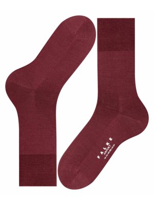 Zwei bordeauxrote Socken, nebeneinander liegend, vor weißem Hintergrund. Die linke Socke liegt mit der Außenseite nach unten, die rechte mit der Innenseite nach unten. Auf der rechten Socke ist ein weißer Schriftzug "Falke Airport" zu sehen.
