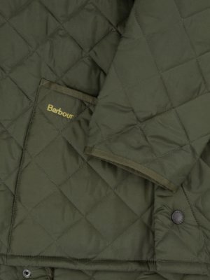 Nahaufnahme einer grünen, rautenförmig gesteppten Jacke. Ein Teil eines Ärmels ist sichtbar, sowie eine aufgesetzte Tasche mit der Aufschrift "Barbour" in gelber Schrift. Die Jacke hat einen runden Knopf.