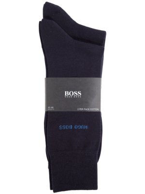 Zwei dunkelblaue Socken in der Packung. Auf einem schwarzen Papierband steht "BOSS HUGO BOSS". Darunter ist der Schriftzug "HUGO BOSS" in blau. Die Socken sind aus Baumwolle. Auf dem Band steht zudem "2 per pack cotton".