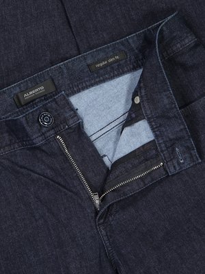Nahaufnahme einer dunkelblauen Jeanshose mit teilweise geöffnetem Reißverschluss. Der Knopf der Hose ist sichtbar. Über dem Bund sind Etiketten von Alberto und "regular slim fit" zu sehen.