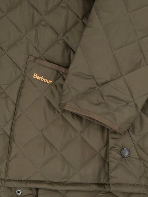 Nahaufnahme einer grünen, gesteppten Jacke. Ein Teil der Jacke mit einer aufgesetzten Tasche und dem Barbour-Logo ist zu sehen. Der Ärmel der Jacke ist ebenfalls erkennbar, die Ränder sind dunkler abgesetzt. Ein Knopf ist unten rechts sichtbar.