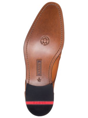 Nahaufnahme der braunen Schuhsohle eines Herrenschuhs. Der Schuh ist aus Leder gefertigt und hat die Marke "LLOYD". Unter der Ferse befindet sich ein schwarzes Gummistück mit rotem Streifen. Auf der Sohle steht "Echt Leder".