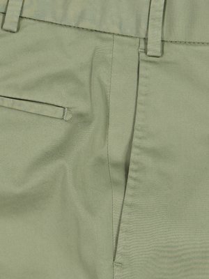 Nahaufnahme einer hellgrünen Hose. Der Fokus liegt auf dem Hosentaschenbereich. Eine Tasche ist sichtbar. Die Hose hat einen Knopf und eine Naht. Der Stoff hat eine leichte Textur.
