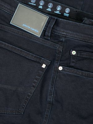 Dunkelblaue Jeanshose von Pierre Cardin. Die Hose zeigt eine Gesäßtasche, einen Hosentaschenknopf und ein Logoetikett. Auf dem Etikett stehen die Produktmerkmale.