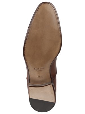 Draufsicht auf die braune Ledersohle eines eleganten Herrenschuhs. Auf der Sohle sind die Marke "Magnanni", die Größe 41 1/2 und ein Absatz zu sehen. Der Schuh hat eine abgerundete Spitze.