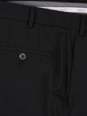 Naheinstellung einer schwarzen Hose. Sichtbar sind eine Gesäßtasche mit Knopf, die Hosenschlaufen, eine Gesäßtasche und ein Teil des Hosenbunds mit dem Label "HILTL" in weißer Schrift. Der Stoff wirkt glatt.
