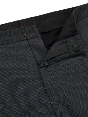 Nahaufnahme des Bundes einer dunklen Hose mit offenem Reißverschluss und Knopf. Das Innenfutter ist schwarz mit roten Ziernähten. Der Reißverschluss ist geschlossen und ein Knopf ist sichtbar. Die Stoffstruktur ist deutlich erkennbar.