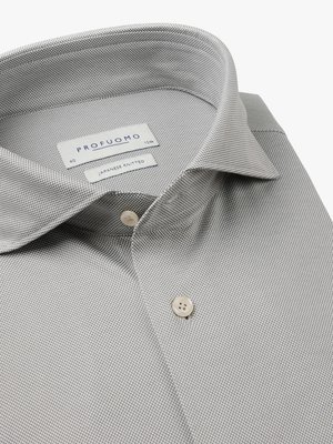 Naheinstellung eines hellgrauen Hemdes aus japanischem Strickstoff. Der Kragen ist offen. Auf dem Hemd befinden sich zwei Knöpfe. Ein Etikett mit dem Aufdruck "PROFUMO" ist sichtbar. Ein weiteres Etikett zeigt "JAPANESE KNITTED".