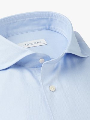 Nahaufnahme eines hellblauen Hemdkragens mit zwei Knöpfen. Ein weißes Etikett mit der Aufschrift "PROFUOMO" ist sichtbar. Die Hemdstruktur ist deutlich erkennbar. Das Hemd ist teilweise geöffnet und hat eine klassische Kragenform.