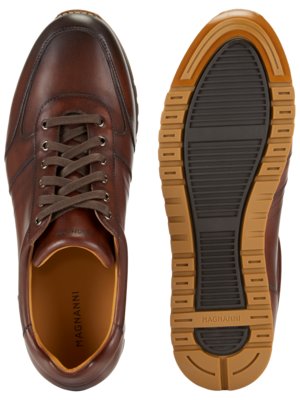 Ein brauner Ledersneaker von oben und die Sohle. Der Sneaker hat braune Schnürsenkel und ein hellbraunes Innenfutter. Die Sohle hat einen braunen Profilgummi mit der Aufschrift "MAGNANNI".