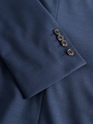 Nahaufnahme eines blauen Anzugsärmels mit vier Knöpfen aus grauem Kunststoff. Der Stoff des Anzugs ist texturiert und hat eine leicht glänzende Oberfläche. Die Knöpfe sind mit Fäden angenäht.