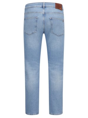 Hellblaue Jeans in Nahaufnahme von hinten. Die Jeans hat zwei Gesäßtaschen und einen braunen Lederaufnäher mit einem Etikett. Das Material der Hose ist aus Denim. Die Hose ist gerade geschnitten.
