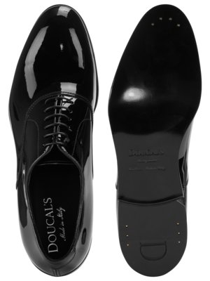 Zwei schwarze Lacklederschuhe mit Schnürsenkeln, einer von oben, einer von unten. Der linke Schuh zeigt die Marke "DOUCAL'S Made in Italy". Der rechte Schuh zeigt die Sohle mit der Aufschrift "DOUCAL'S".