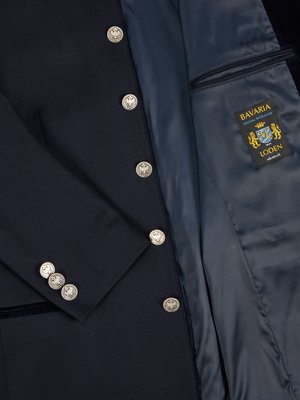 Nahaufnahme einer dunkelblauen Jacke mit silberfarbenen Knöpfen und Innenfutter. Die Jacke hat eine Reihe von Knöpfen auf der rechten Seite. Im geöffneten Inneren ist ein Label zu sehen.