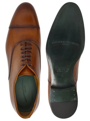 Ein brauner Lederschuh mit Schnürsenkeln ist abgebildet, daneben die Schuhsohle mit Aufdrucken. Die Sohle ist dunkelgrün und zeigt den Schriftzug "SCHUHKANDWERK" und "VERO CUOIO MADE IN ITALY". Die Schuhgröße "41" ist ebenfalls abgebildet.