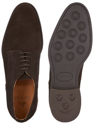 Draufsicht auf einen braunen Wildlederschuh und die Schuhsohle. Der Schnürschuh ist mit Schnürsenkeln versehen und zeigt das Innenfutter. Die Sohle hat ein kreisförmiges Profil und das Vibram Logo.