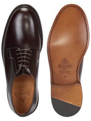 Zwei Ansichten eines braunen Lederschuhs. Links ist der Schuh mit Schnürsenkeln abgebildet. Rechts die Unterseite des Schuhs aus braunem Leder, mit Markenschriftzug und Größe.