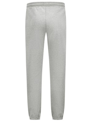 Hellgraue Jogginghose von hinten fotografiert. Sie hat einen elastischen Bund, zwei Seitennähte und Bündchen an den Knöcheln. Das Material sieht weich und leicht strukturiert aus. Die Hose ist in neutraler Position.
