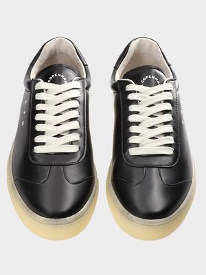 Zwei schwarze Sneaker aus Leder, von oben fotografiert. Beide Schuhe haben cremefarbene Schnürsenkel und eine helle Sohle. Auf der Innenseite steht "COPENHAGEN". Das Leder ist glatt und glänzend. Auf der Außenseite befinden sich weiße Punkte.
