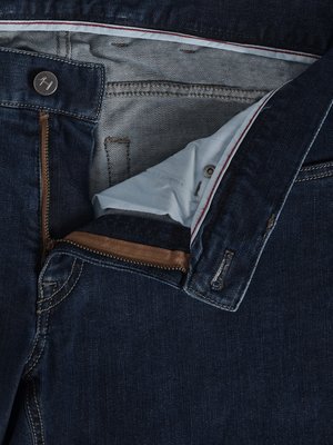 Nahaufnahme einer Jeanshose mit geöffnetem Reißverschluss. Der Knopf und der Hosenschlitz sind sichtbar, der Reißverschluss ist braun. Die Innenseite des Hosenbundes ist hellblau gefüttert mit roter Naht. Der Stoff der Hose ist dunkelblau.