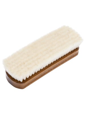 Eine Schuhputzbürste, die diagonal von oben links nach unten rechts im Bild positioniert ist. Der Griff ist aus dunklem Holz gefertigt, während die Bürstenborsten hellbeige sind. Die Borsten sind weich und dicht.