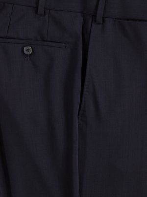 Nahaufnahme einer dunklen Hose aus Stoff. Man sieht eine Gesäßtasche mit Knopf, einen Eingriff und eine Naht, sowie einen Teil des Hosenbunds. Der Stoff wirkt glatt und leicht glänzend.